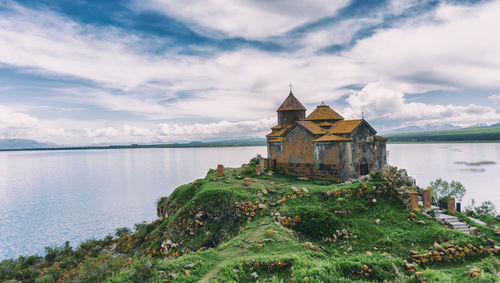 Historic building by water against sky