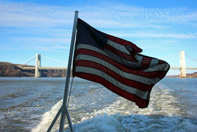 Scenic view of flag on sea against sky