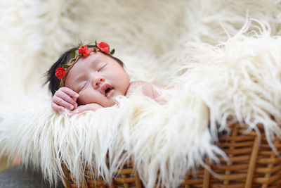 Close-up of cute baby girl sleeping on rug at home