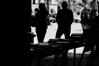 Rear view of silhouette man and woman walking in corridor