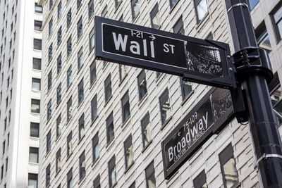 Low angle view of road sign against buildings in city