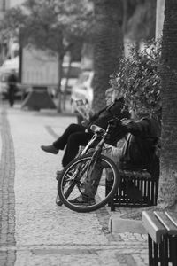 Man with bicycle on sidewalk in city