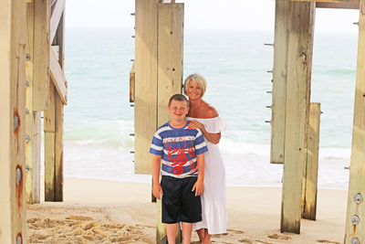 Full length of friends standing on beach