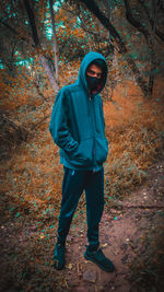 Full length portrait of man standing in forest