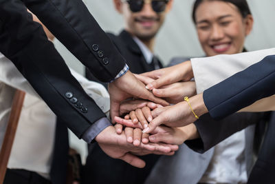 Midsection of business people stacking hands