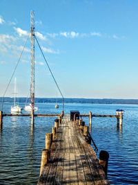 Pier over sea against blue sky