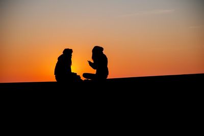 Silhouette man standing against sky during sunset