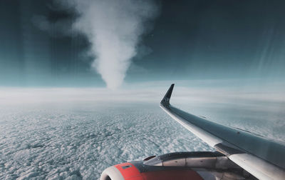 Airplane flying over sea against sky