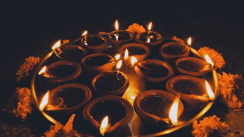 High angle view of lit candles burning at night