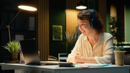 Side view of young woman using mobile phone at table