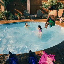 Young child jumping into pool 