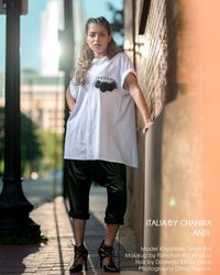 Full length portrait of woman standing against building