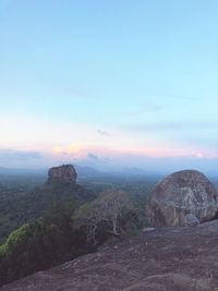 Rock formations on landscape against sky during sunset