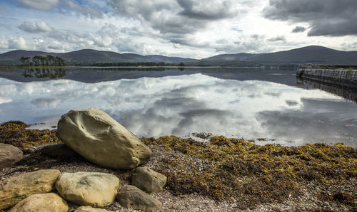 Close-up of rocks in lake against sky