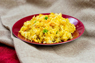 High angle view of rice in plate on fabric