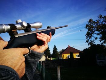 Midsection of man with arms outstretched against sky