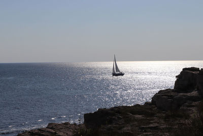 Sailboat in sea against clear sky