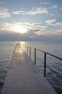 Pier on sea at sunset