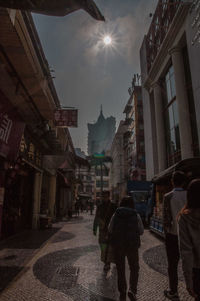 Man walking on illuminated city against sky