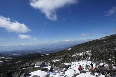 High angle view of people standing snowcapped mountain against sky