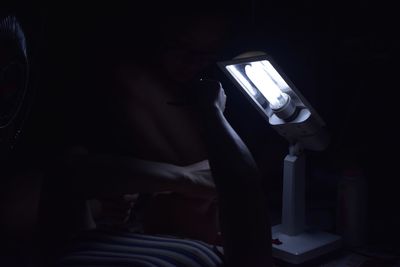 Close-up of hand photographing illuminated smart phone