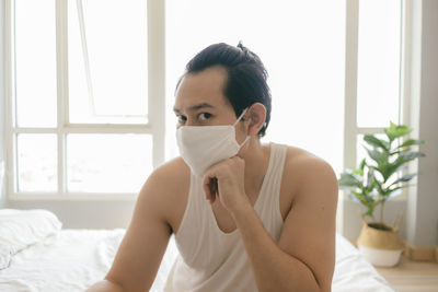 Long hair man with hygienic mask is bored of being quarantine.