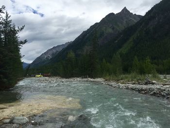 Scenic view of river amidst mountains against sky