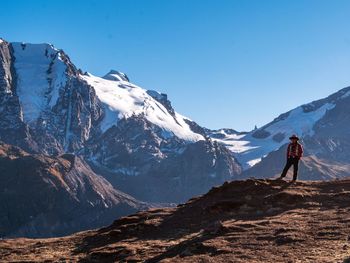 Full length of man standing on rock against mountains and sky