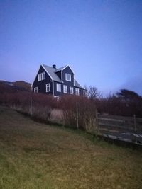 House on field against clear sky