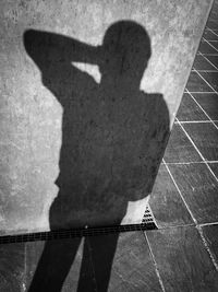 Shadow of person sitting on floor in city