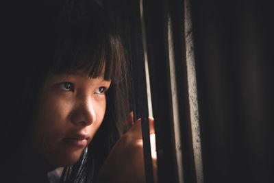 Close-up of girl looking through window