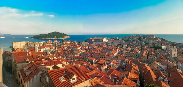 High angle view of townscape by sea against sky