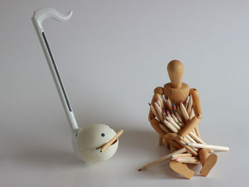 Close-up of figurine on table against white background