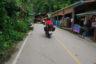 People riding motorcycle on road in city