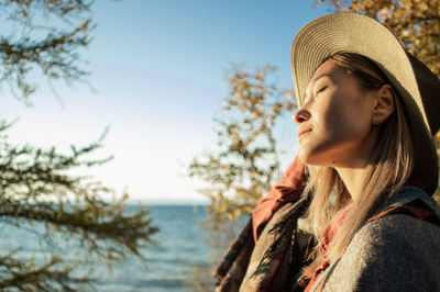 Portrait of woman looking at sea against sky