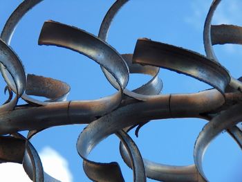 Low angle view of metallic structure against blue sky