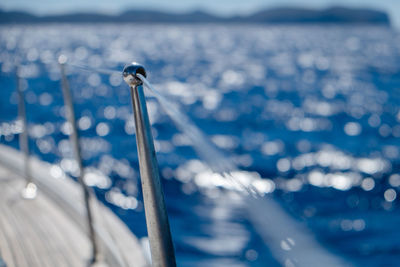 Close-up of sailboat sailing on sea against sky