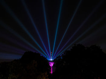 Low angle view of illuminated lights against sky at night