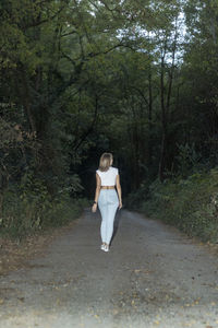 Portrait of young woman walking on road