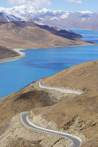 Scenic view of lake by mountains against sky