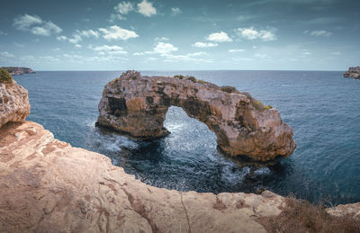 Rocks on sea shore against sky