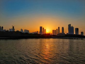 City buildings against sky during sunset