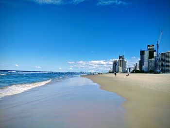 Scenic view of sea and buildings against blue sky