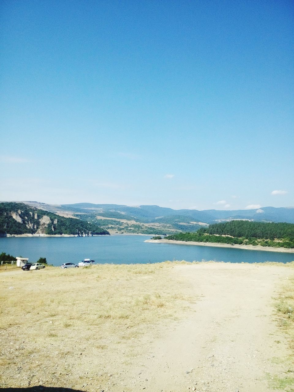 water, clear sky, copy space, blue, tranquil scene, tranquility, scenics, beauty in nature, nature, lake, beach, shore, mountain, sand, idyllic, sea, river, outdoors, day, sky