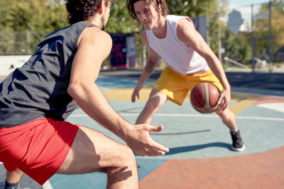 Men playing basket ball in sports court