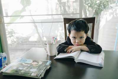 Portrait of boy sitting on table