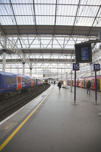 Train at railroad station in city against sky