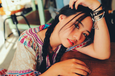 Portrait of young woman lying on wooden table
