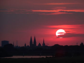 Silhouette building against sky during sunset