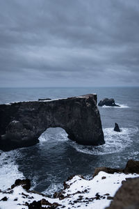 Rock formation in sea against sky